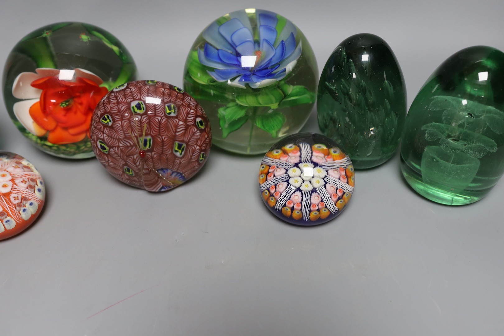 A collection of nine glass paperweights including Victorian dumps and millefiori